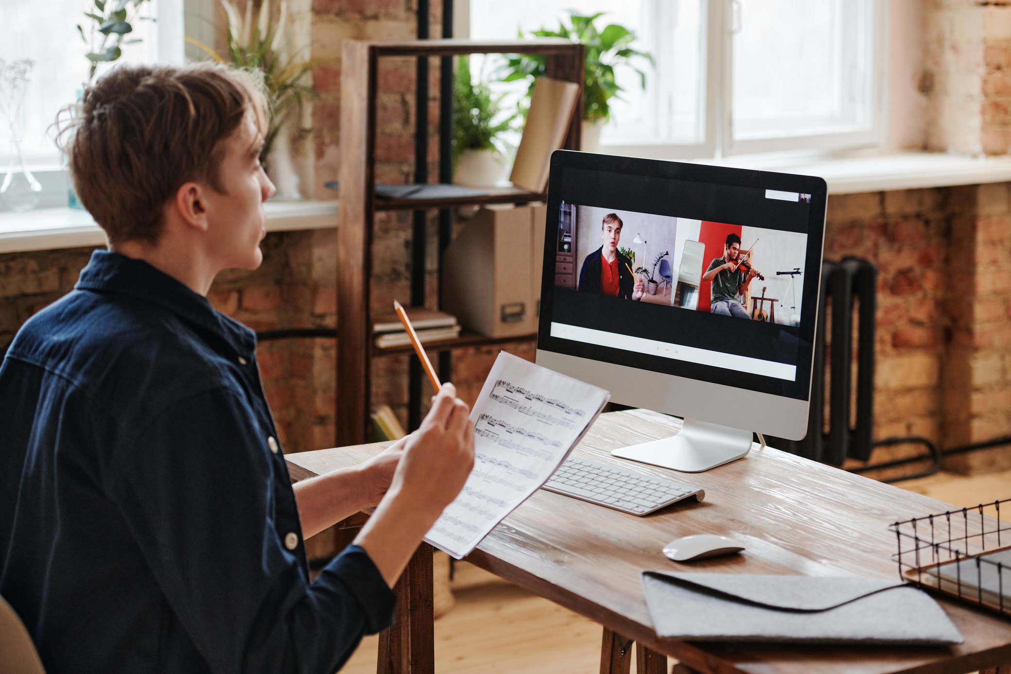 A Man Holding a Pencil and a Music Conducting an Online Tutorial